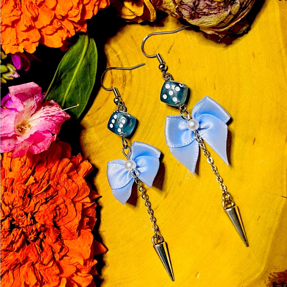 Blue Bows and Dice dangle earrings with swinging silver pendulum.